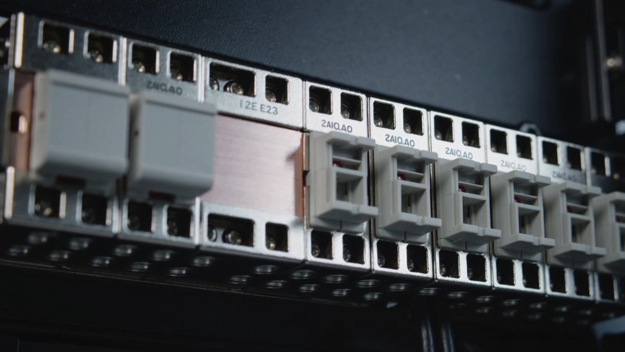 Zooming camera revealing rack adapter panel in rack, highlighting beige adapters, SFPs, port labels