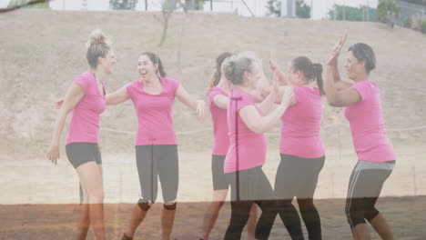 celebrating outdoors, women in pink shirts high-fiving with joy and animation