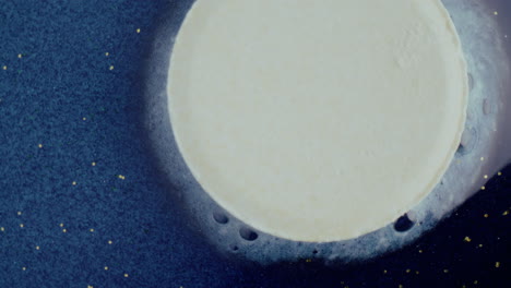 round cream dessert on dark blue background with glitter
