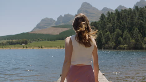 happy-woman-running-on-jetty-with-arms-raised-ready-to-jump-in-lake-celebrating-freedom-enjoying-summer-vacation