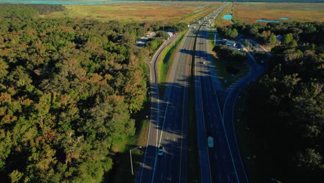 Trucking-rest-stop-beside-highway,-parked-trucks-and-surrounding-greenery