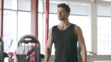 Handsome-man-doing-lunges-exercise-with-dumbbells-in-fitness-club.