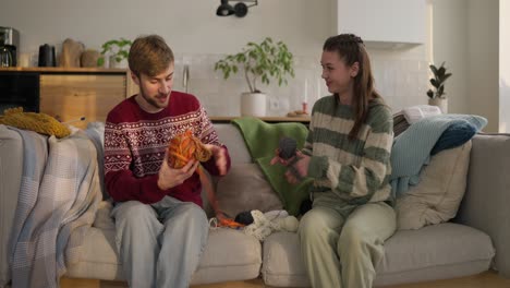 couple knitting together on a couch