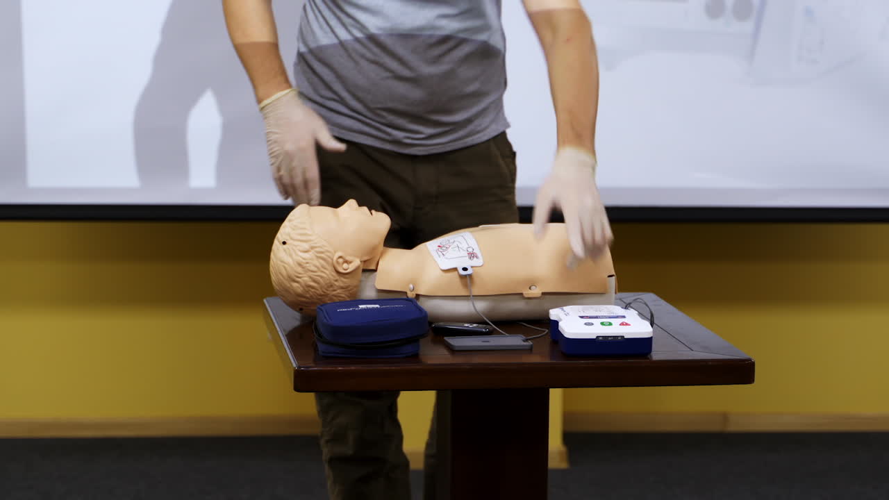 Trainer teaching medical skills on a mannequin. Instructor showing practical methods for giving first aid on a dummy. Healthcare and medical concept.