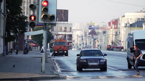 city street scene at dawn/morning with traffic and pedestrians