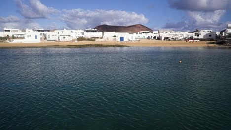 在西班牙的拉格拉西奧薩 (la graciosa) 的海岸,風吹著,有白色的建築和房子,而地平線在晴天和雲端的距離中可見.