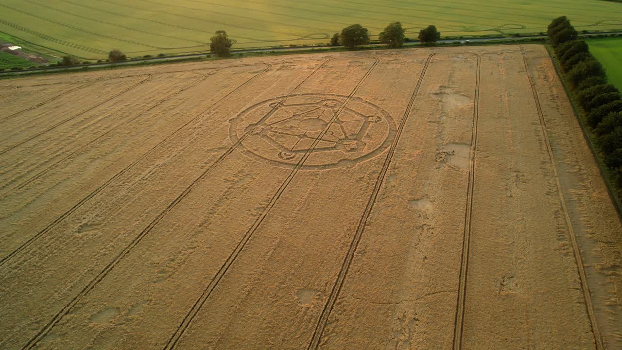 Wiltshire wheat field countryside crop circle molecular pattern aerial view rural scene orbit left n at sunset