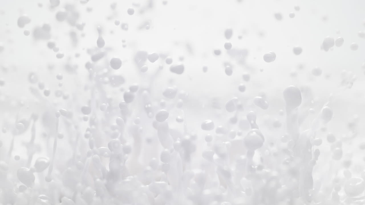 우유와 같은 추상적인 색 페인트가 매크로와 느린 동작으로 어지고 방울을 만들어니다.