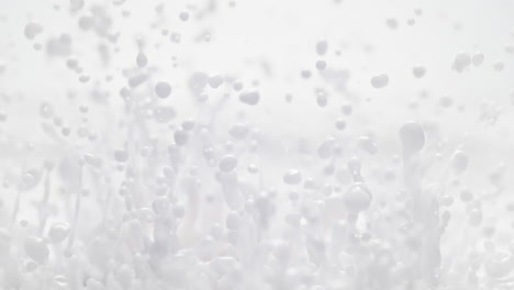 pintura blanca abstractamente lechosa salpica y hace gotas en macro y cámara lenta