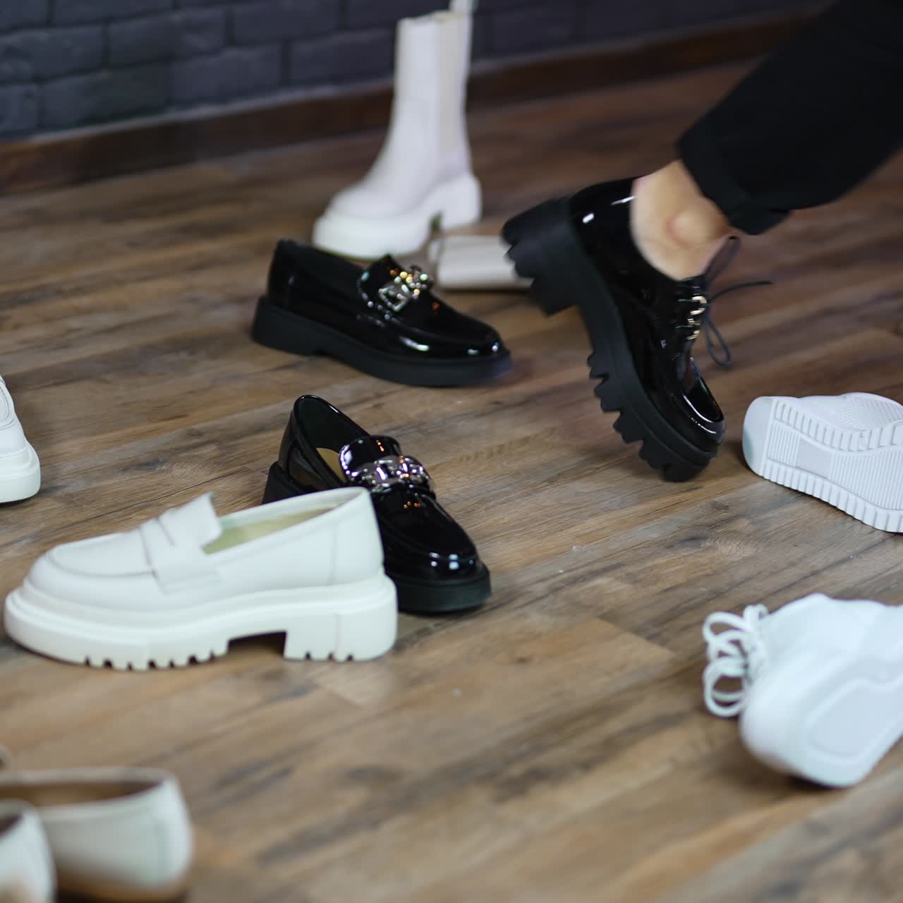 Walking among the demonstrated footwear. Woman model moves shoes on the way to walk in chosen black pair of shoes