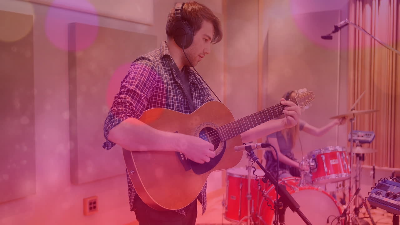 Bandmates playing acoustic guitar and drums in recording studio, with animated sound waves overlay