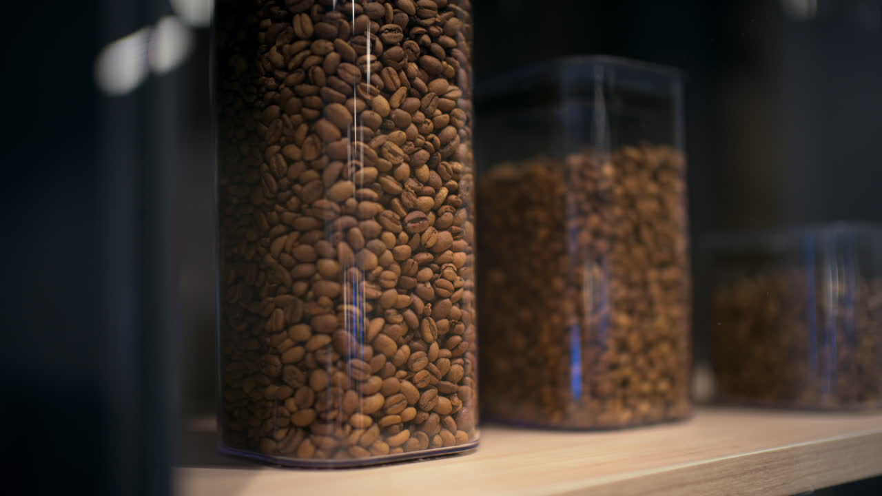 Close up of coffee beans stored inside transparent containers of different heights