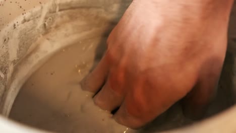 close-up of potter preparing mud