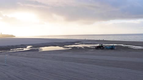 el trator caminando en una playa desierta con un gran amanecer.