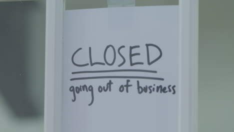 a going out of business sign is taped to a shutting door