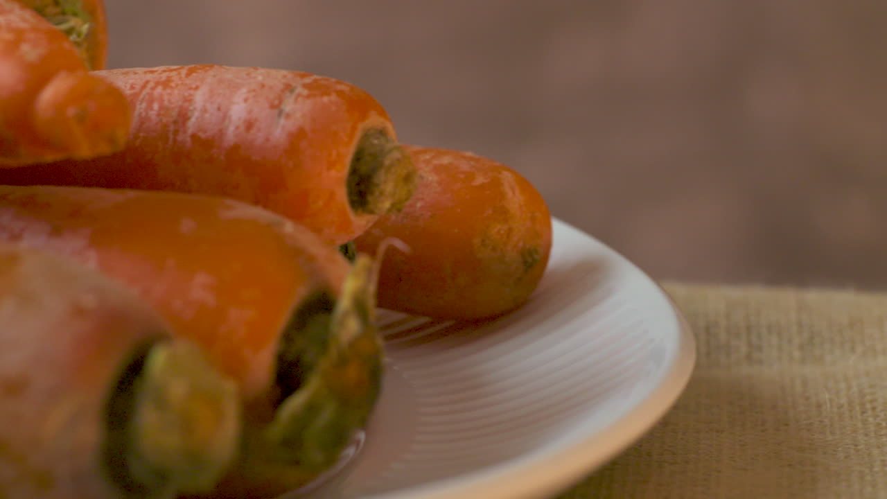 Close-up on a plate of freshly picked, raw, whole carrots