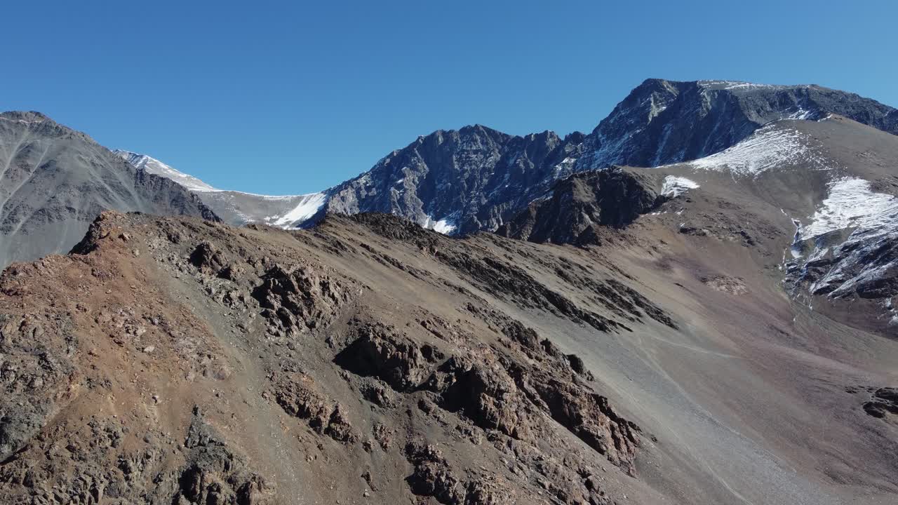 vista aérea de picos de montañas alpinas estériles con polvo de nieve