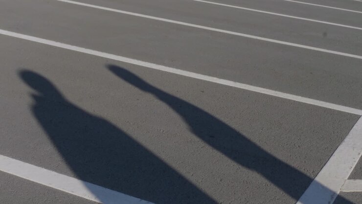 Shadows of two people on a parking lot