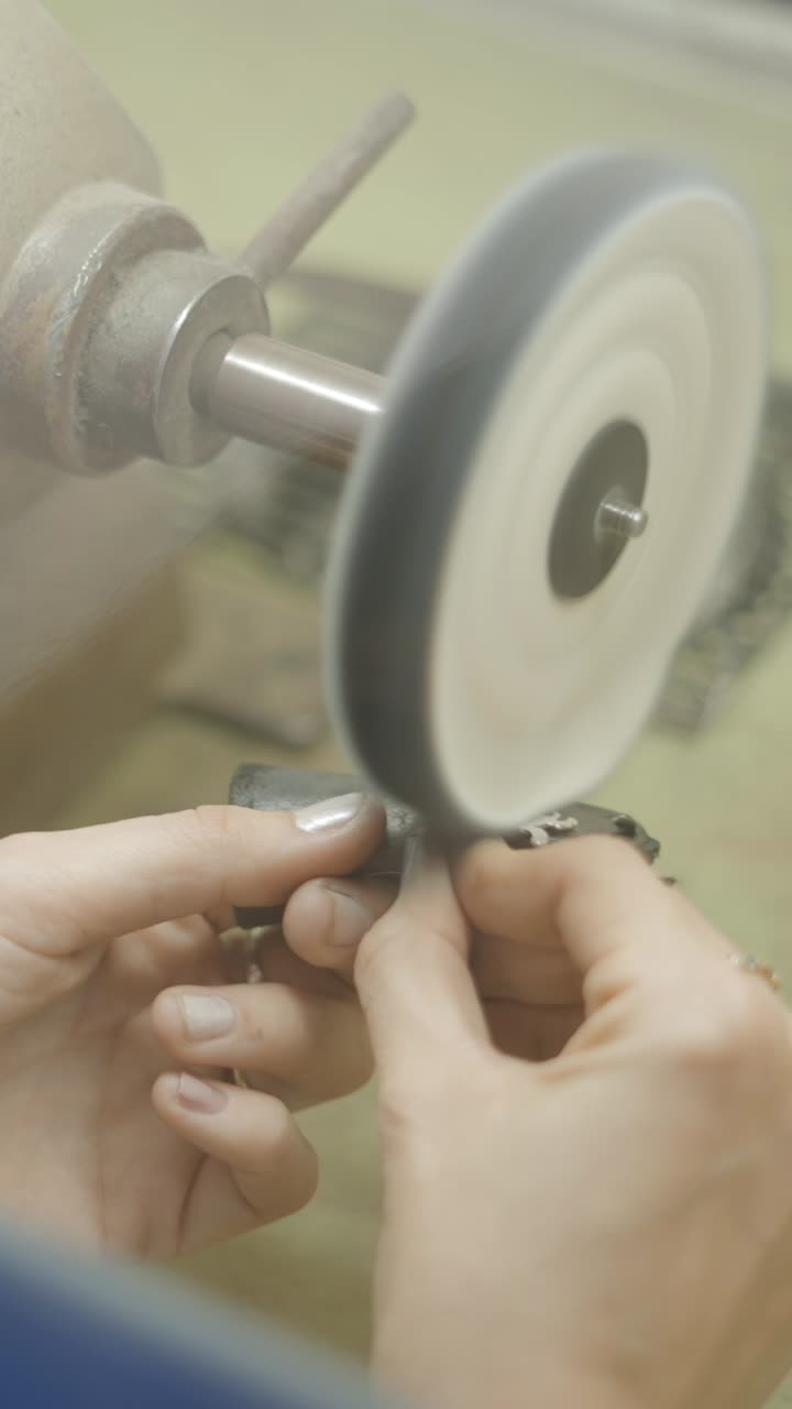Hands Polishing Metal on a Grinding Wheel in a Workshop