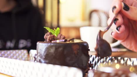 Luz-Natural-Cerca-De-La-Mano-De-Una-Mujer-Tomando-Un-Trozo-De-Un-Coulant-Casero-De-Chocolate-Para-El-Postre