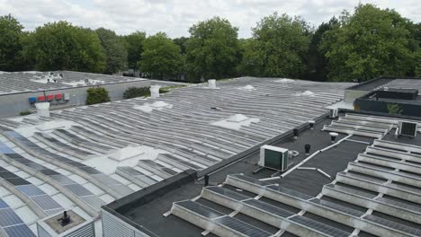 low aerial of photovoltaic solar panels on a flat rooftop of an office building