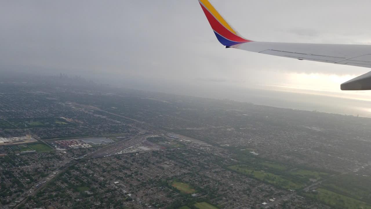 volando en un avión y mirando por la ventana a la ciudad de abajo