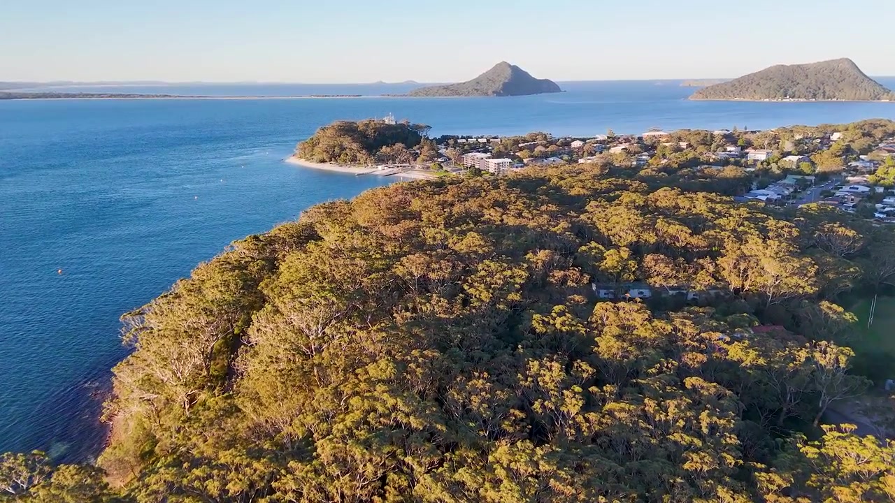 Vista aérea de drone de promontório verde exuberante e cidade costeira à beira-mar em Nelson Bay