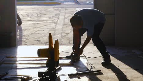 manual worker grinding welded metal joint in a fabrication factory. static