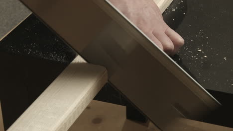 close up: box saw hand tool used to cut white pine lumber on table top