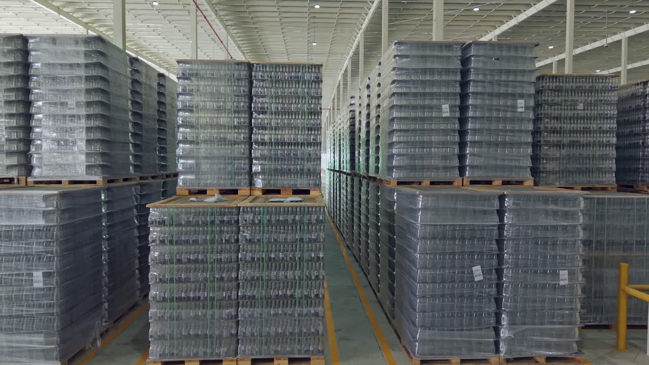 Brewery warehouse, stacks of empty beer bottles on pallets. Sideways shot