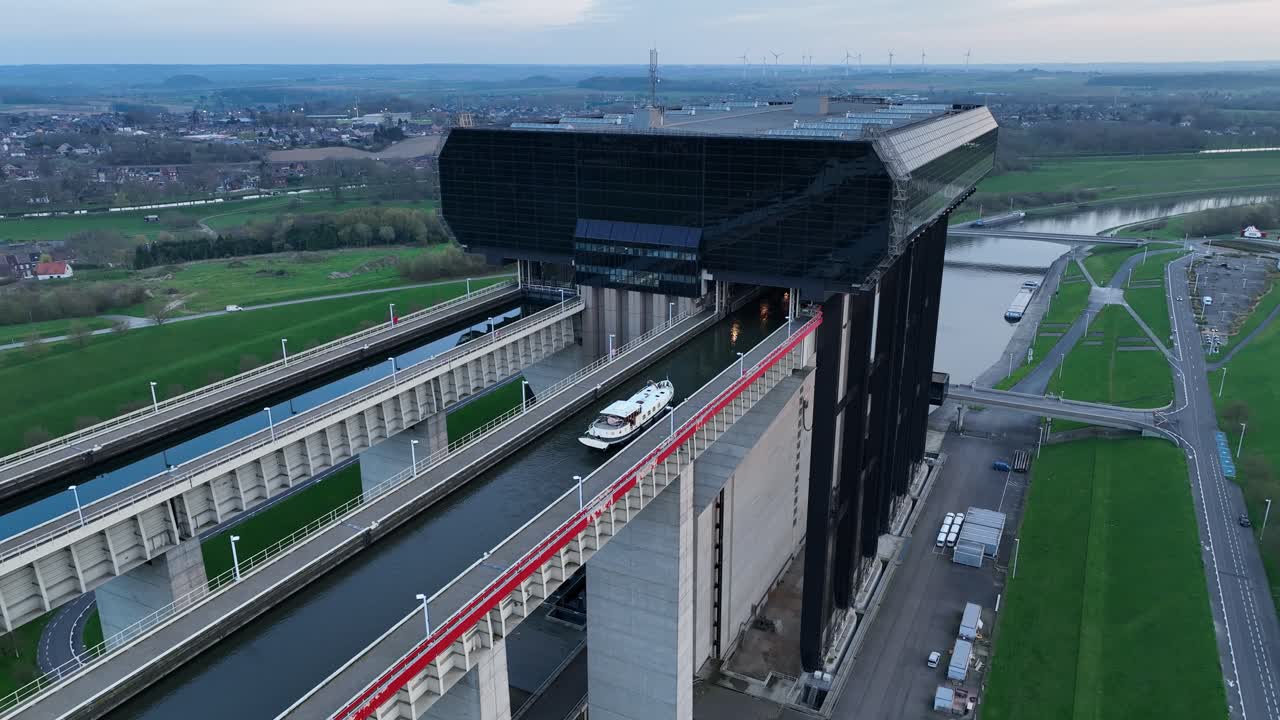Zoom in revealing a boat moving across the upper canal of the Strépy-Thieu boat lift in Le Roeulx at blue hour