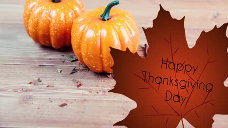 animation of thanksgiving text on leaf over pumpkins on wooden surface