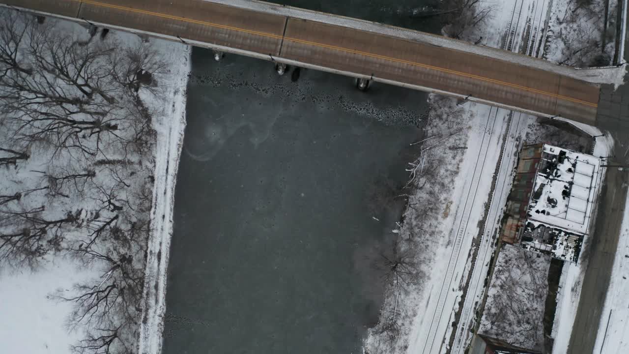 도시 지역의 얼어붙은 강과 작은 도로 교량의 하향식 조감도