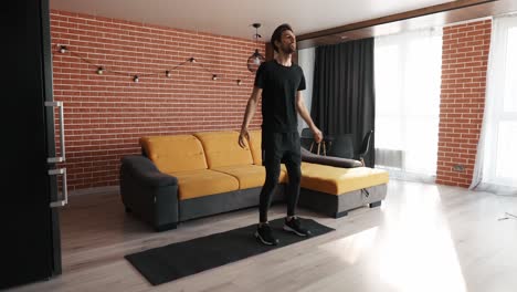 young man doing squats and exercising at home