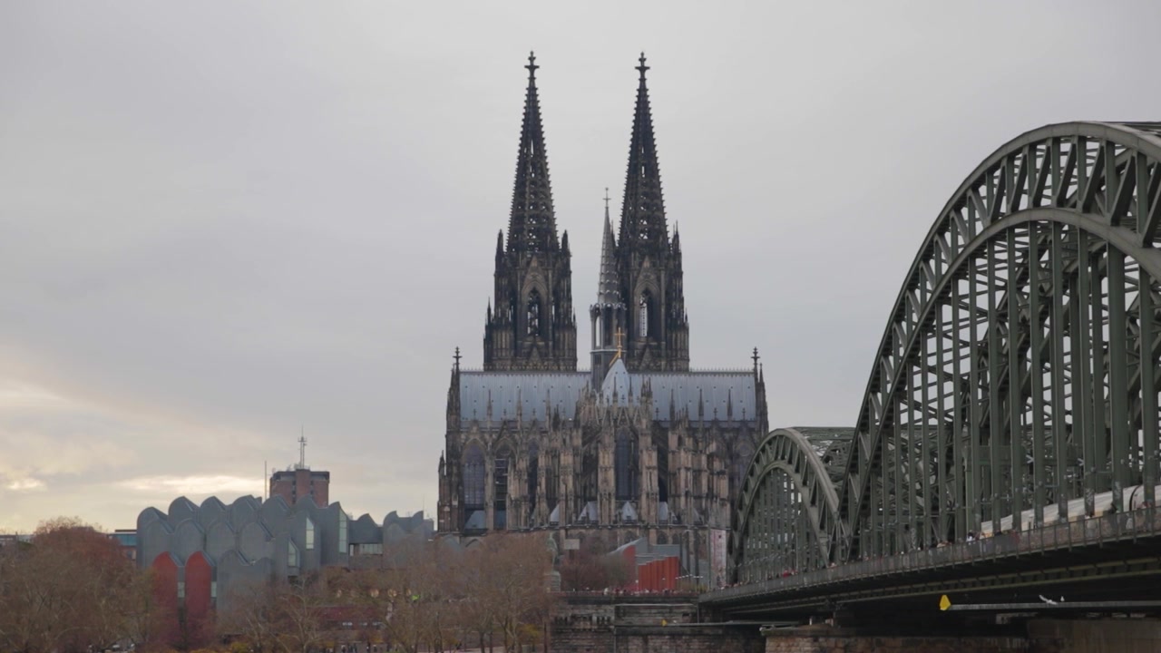 A medium shot of the Cologne Cathedral, Germany's most visited landmark, and the Hohenzollern bridge, the most heavily used railway bridge in Germany.