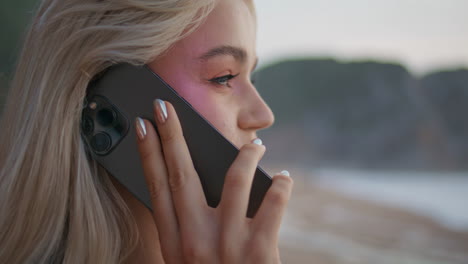 closeup girl calling smartphone outdoors side view. smiling pretty blonde talk