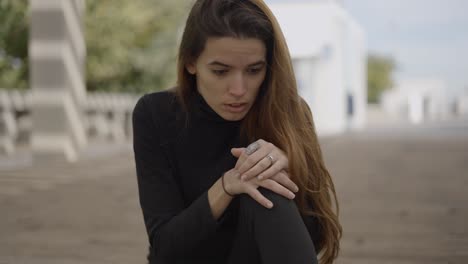 woman sitting pensively outdoors