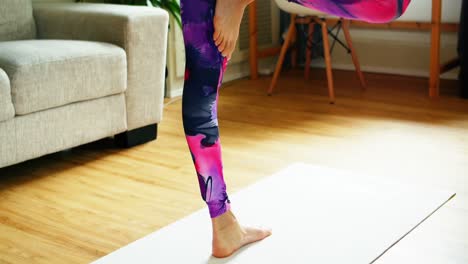 hermosa mujer practicando yoga en la sala de estar