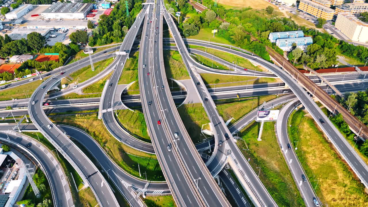 Complex highway interchange in Europe. Aerial view of a busy highway interchange with multiple lanes and vehicles moving in various directions on a bright day