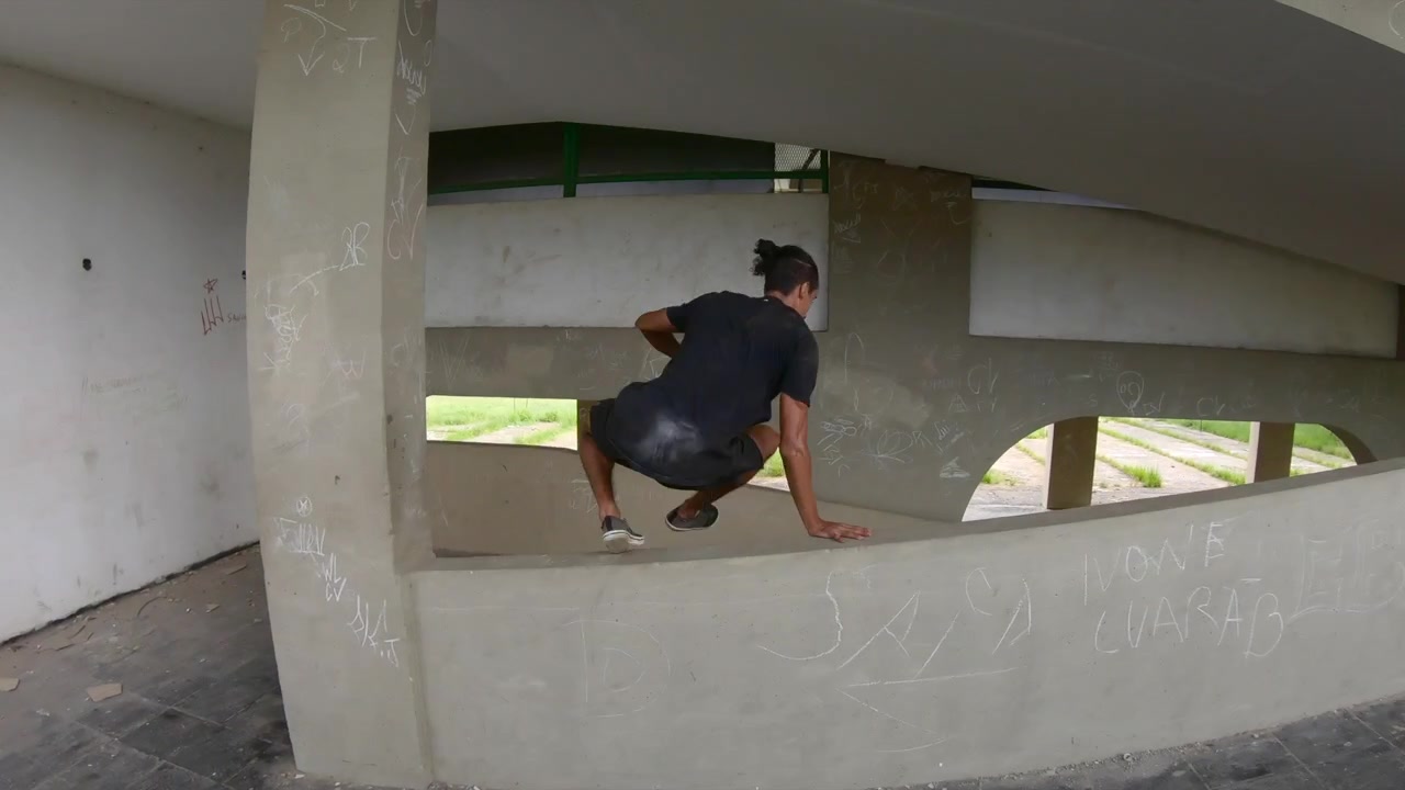 Due freerunner che si calano da una casa nel parco dal piano superiore per eseguire dei salti.