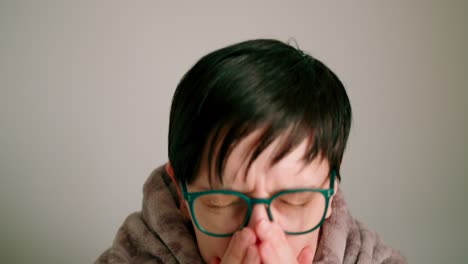 Close-up-view-of-Lady-with-glasses-sneezing--coughing-into-scarf