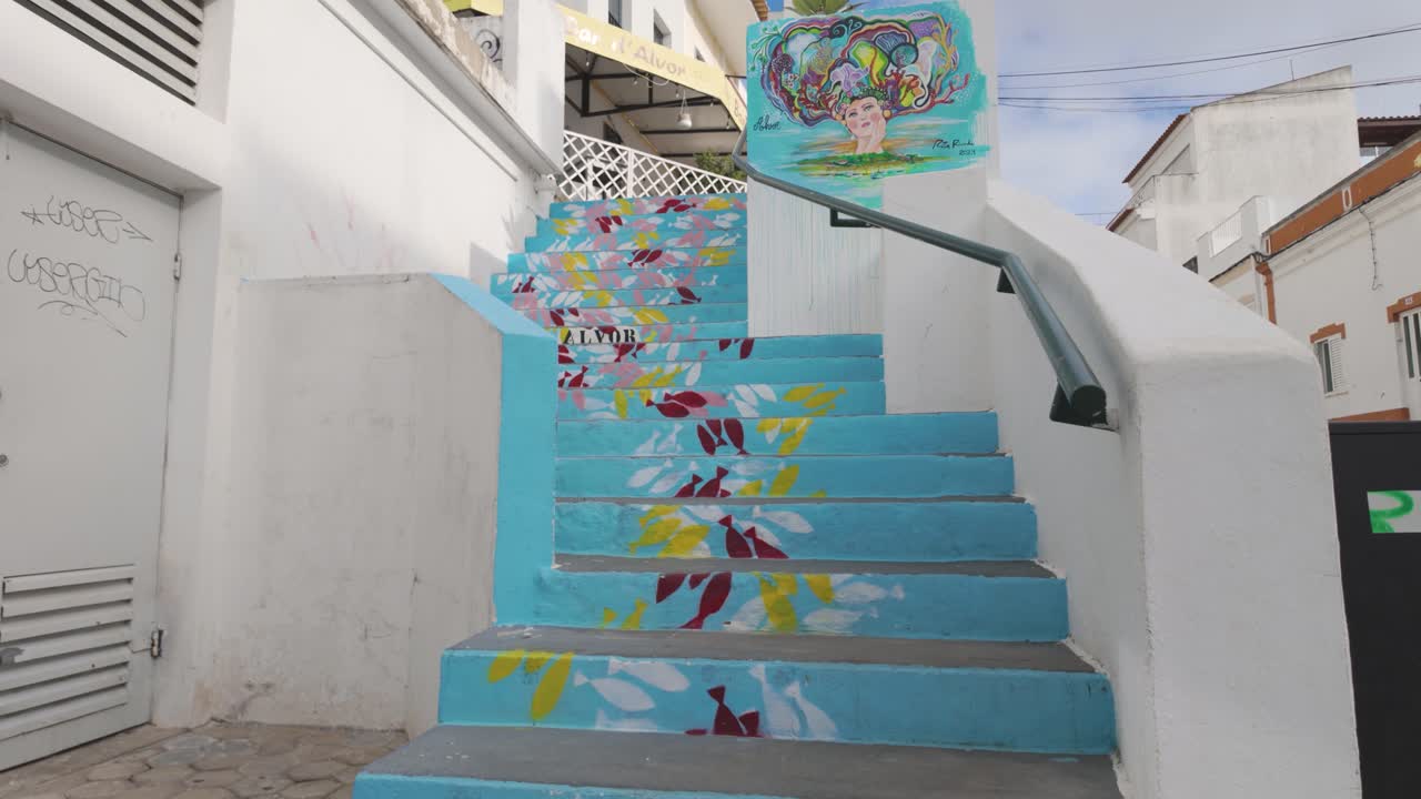 Vibrant fish themed street art on blue stairs in Alvor Portugal Algarve