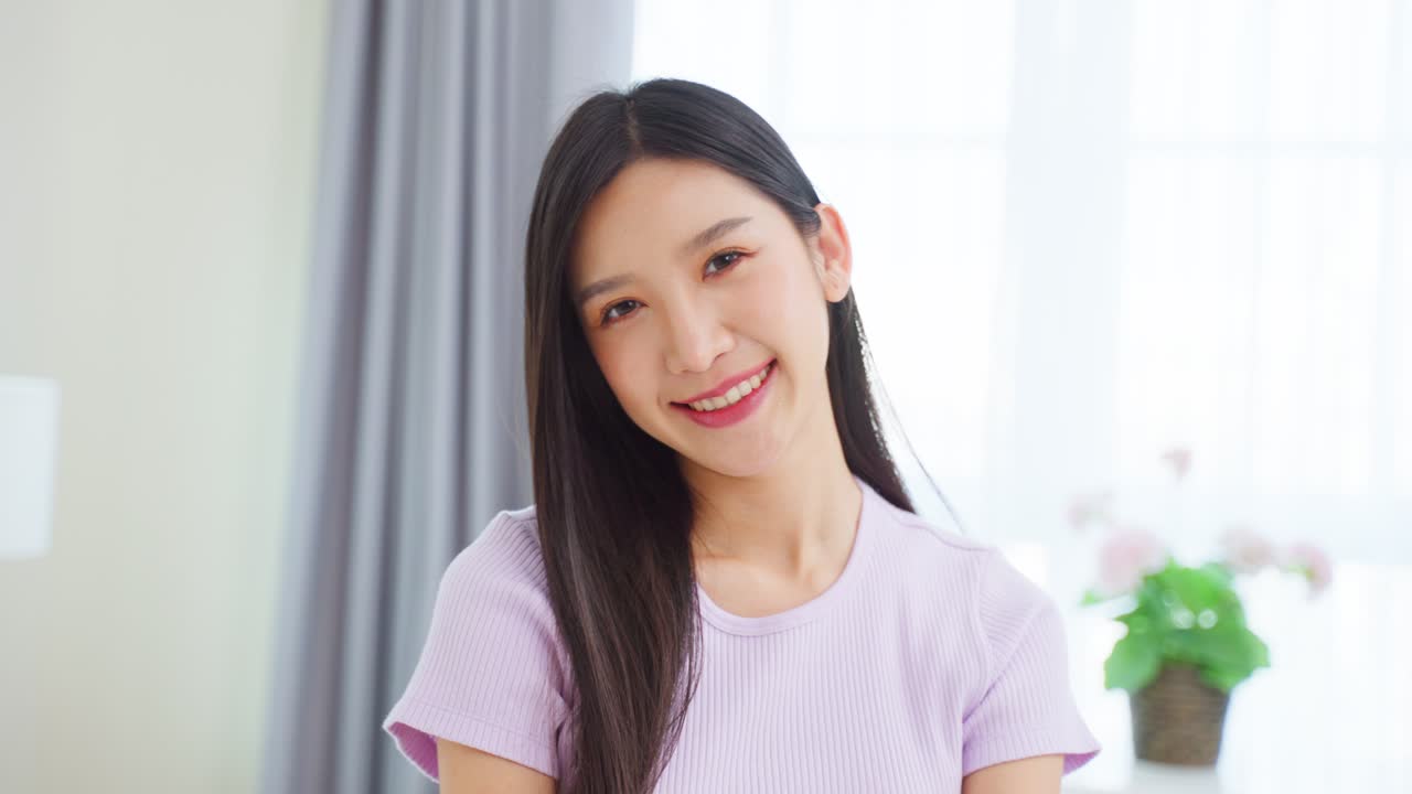 보라색 셔츠 를 입은 미소 짓는 아시아인 여자