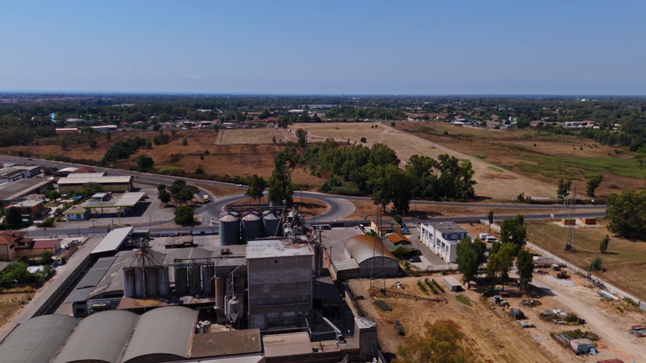Vista aerea di un grande elevatore di grano e di un impianto di trasformazione agricola. Silos industriali che immagazzinano colture e materie prime in un'area rurale.