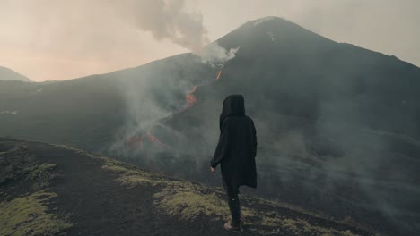 pacaya volcano, guatemala - a person is walking near the volcano to observe the flowing rivers of lava up close - tracking shot