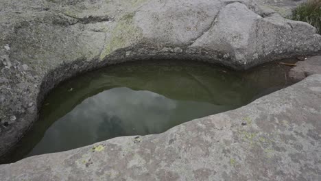 View-from-the-top-of-a-carved-rock-pool-called-cisterns-that-do-not-dry-out-even-in-the-hottest-days-on-top-of-Belintash-Plateau,-located-at-Rhodope-mountain-in-Plovdiv-province-in-Bulgaria