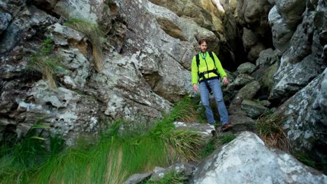 male hiker getting out from a cave 4k