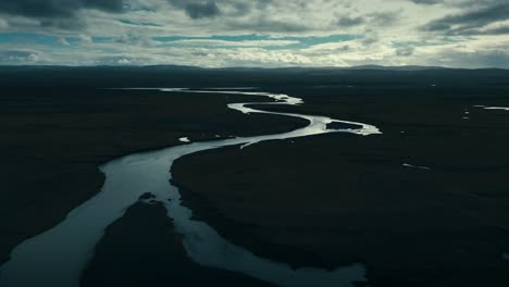 Drohnenaufnahme-Eines-Sich-Windenden,-Schlangenartigen-Flusses-In-Der-Kühlen-Dunkelheit-Der-Bedrohlichen-Wolken