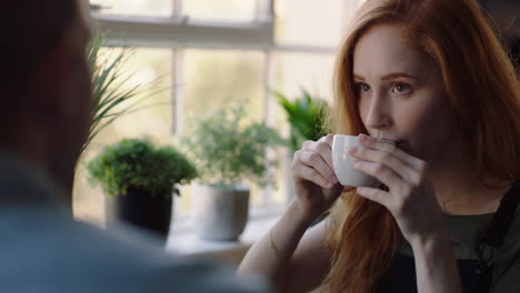 beautiful young woman in cafe talking to friend drinking coffee enjoying relaxed conversation chatting together socializing in restaurant shop