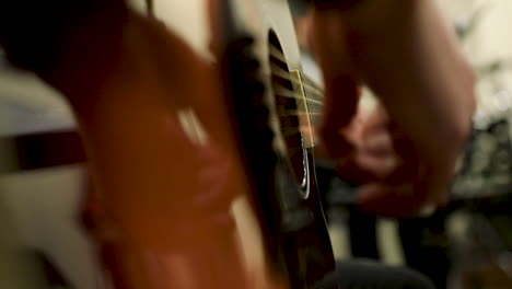 a male hand playing the guitar in the studio - close up